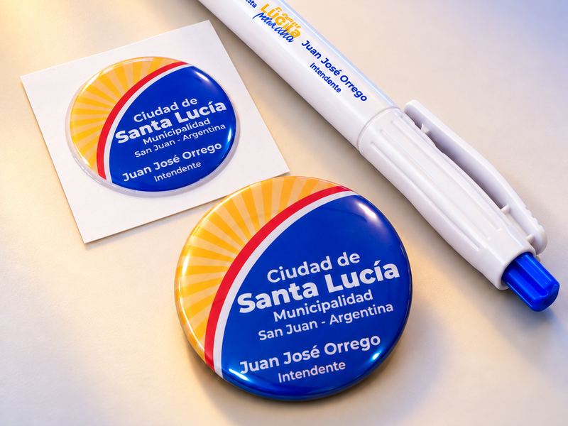 Pin metálico, calco con resina y bolígrafo institucionales para la Municipalidad de Ciudad de Santa Lucía, San Juan, por TramaHub