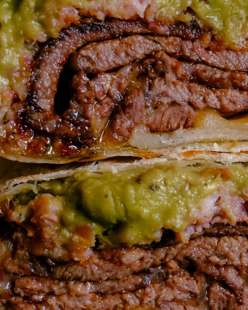 Wrap de carne asada con guacamole y queso, cortado al medio, producto de Hendrix